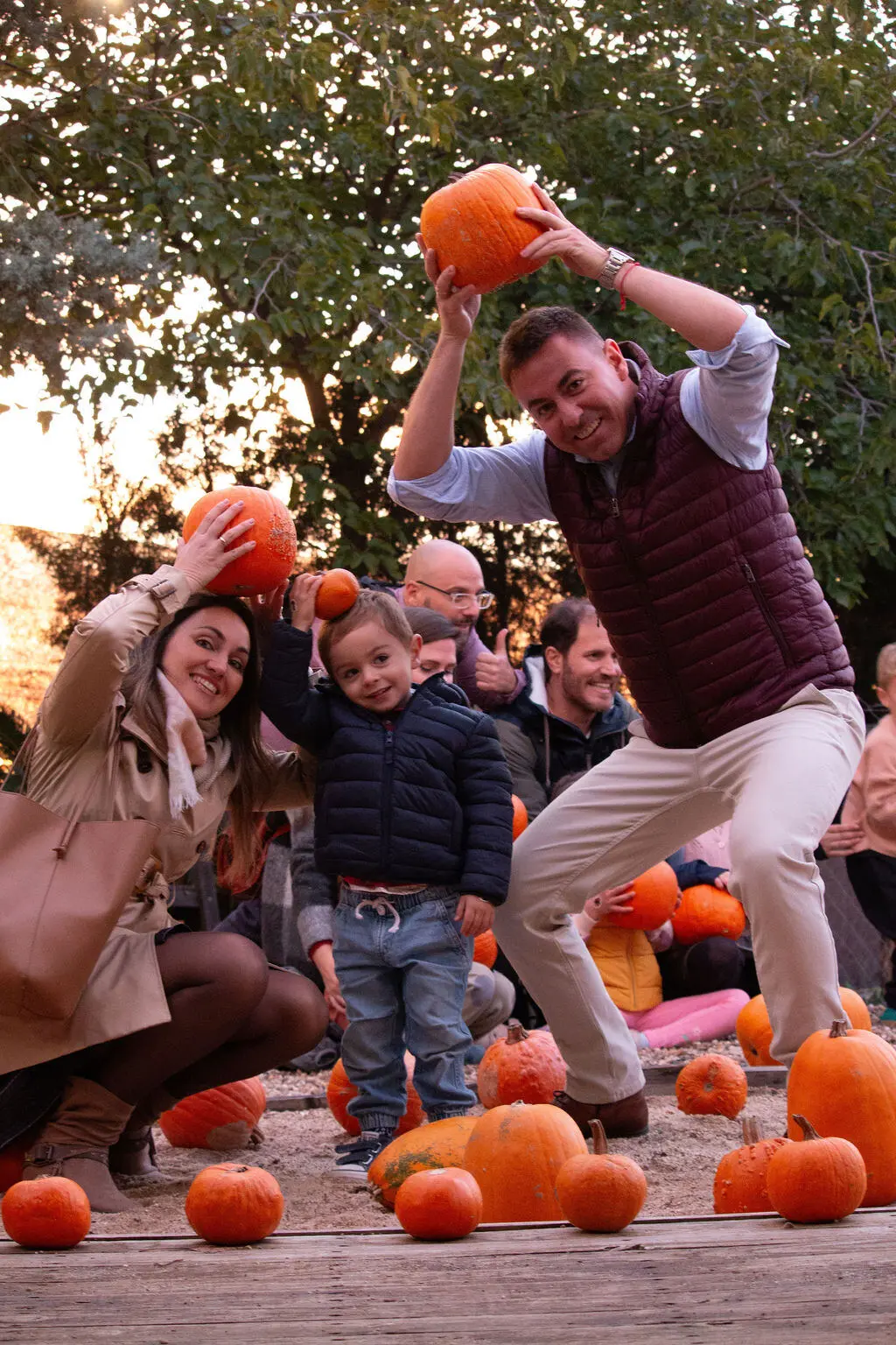 Familia jugando con calabazas al atardecer en Ecoterránea